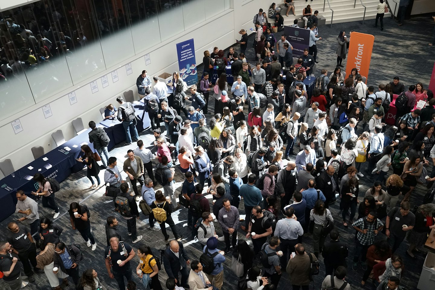 Grupo diverso de personas haciendo networking en una feria empresarial interior.