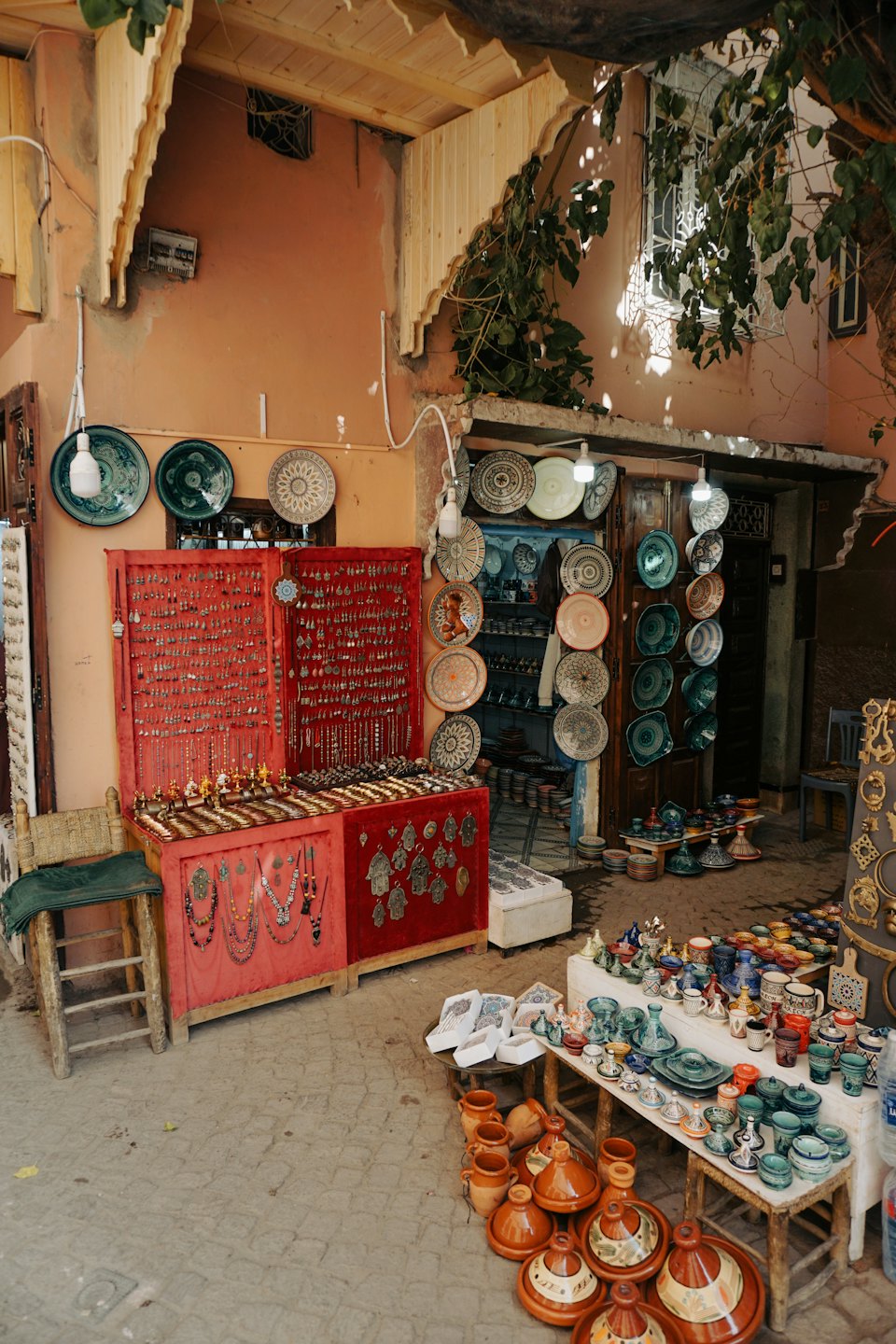 Puesto de mercado al aire libre con joyas de plata y cerámica colorida.